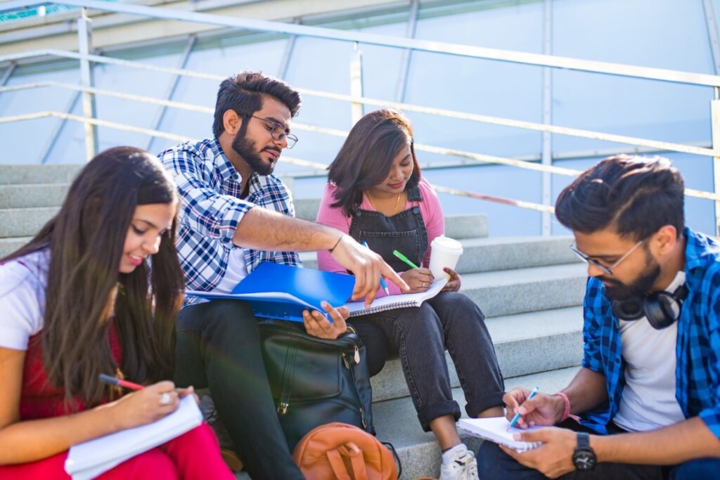 Young Indians hanging out with each other and sitting on stairs.