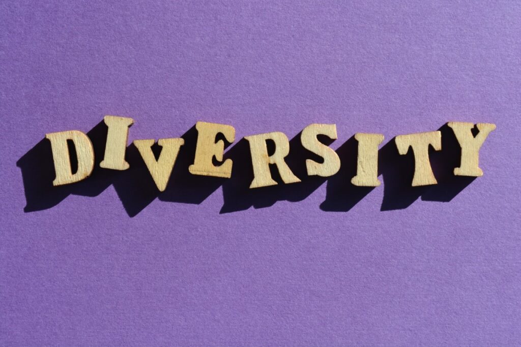 Diversity, word in wooden alphabet letters isolated on purple background.