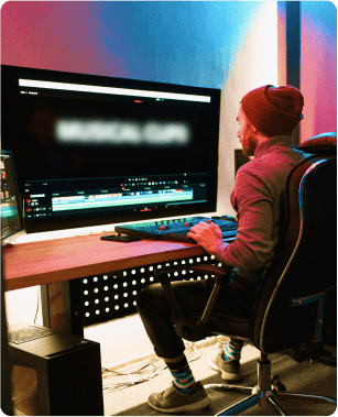 A man sitting at a desk in front of a monitor.