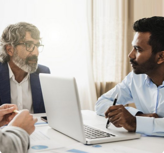 2 Men Discussing Work Over Table